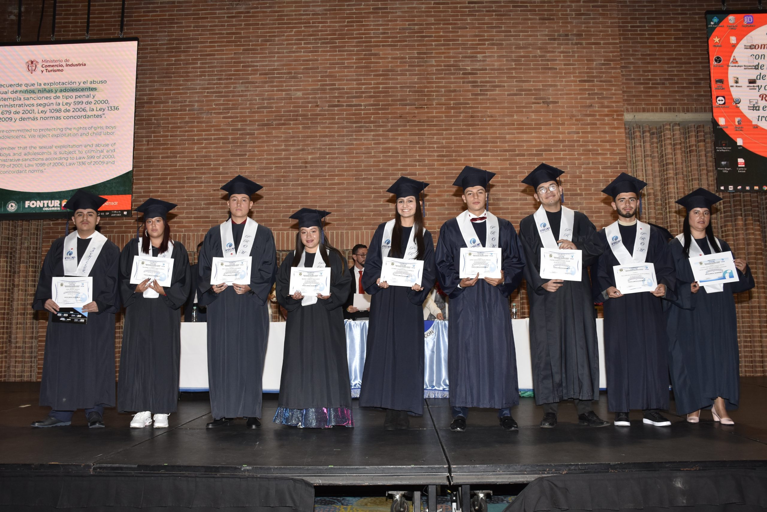 Un grupo de amigos graduados abrazándose y celebrando con sus birretes.